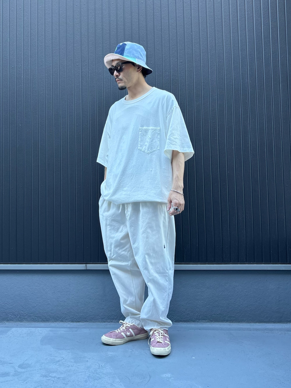 ホワイト系のその他パンツ、ホワイト系のTシャツ/カットソー、ピンク系のスニーカーを着用したメンズの夏コーディネートの3枚目の写真