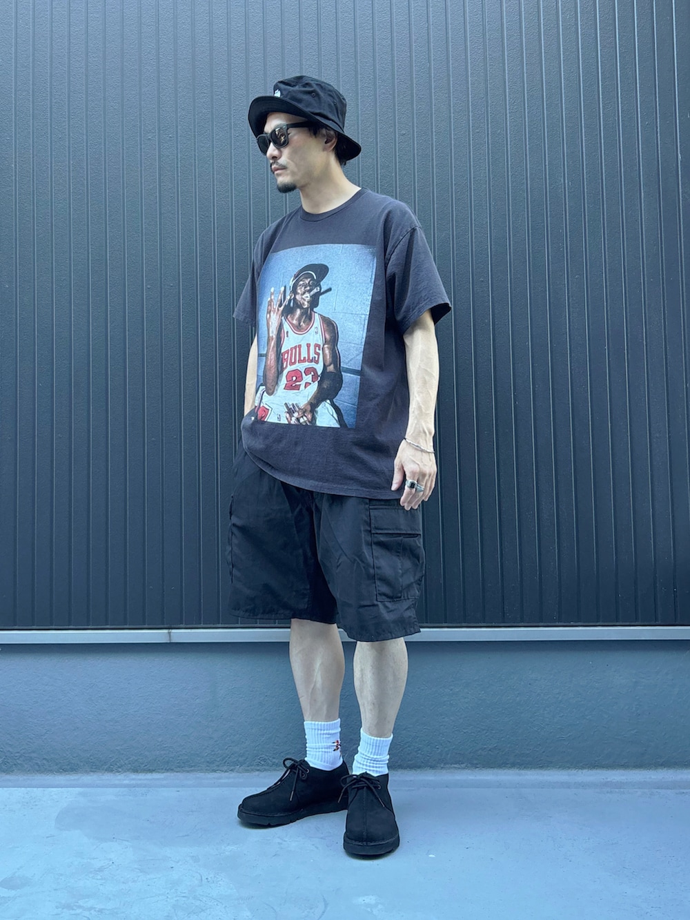 ブラック系のTシャツ/カットソー、ブルー系のモカシン/デッキシューズ、ブラック系のパンツを着用したメンズの夏コーディネートの3枚目の写真