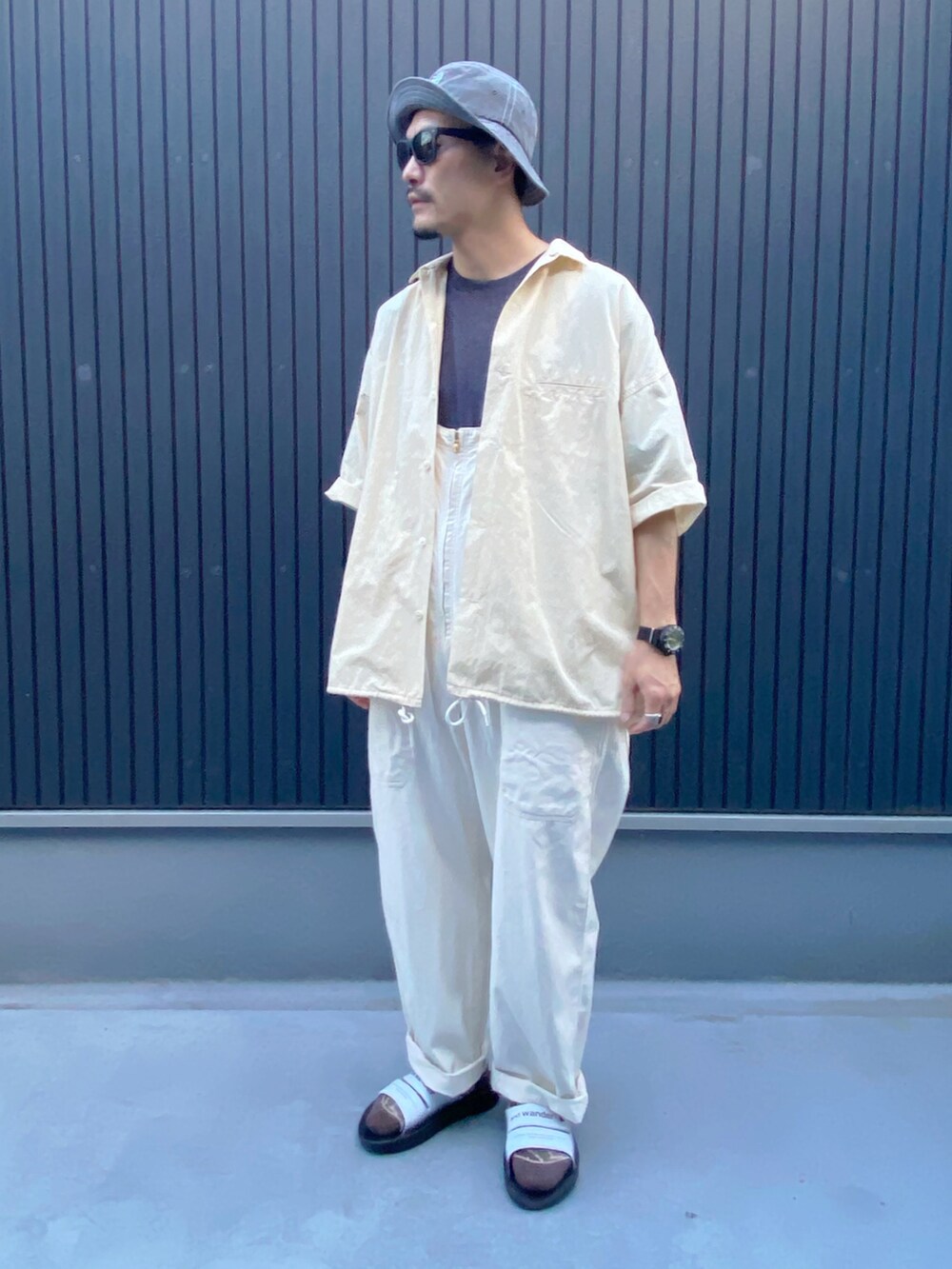 ベージュ系のトップス、ブラック系のTシャツ/カットソー、ホワイト系のサロペット/オーバーオールを着用したメンズの夏コーディネートの3枚目の写真