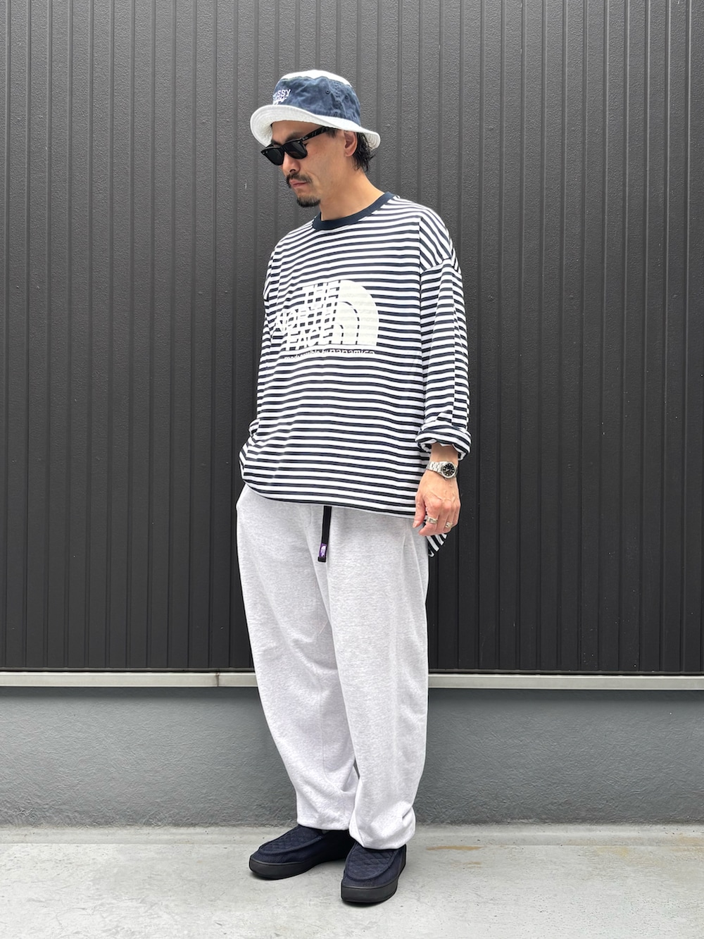 ブルー系のスニーカー、その他のTシャツ/カットソー、グレー系のスウェットパンツを着用したメンズの春コーディネートの3枚目の写真