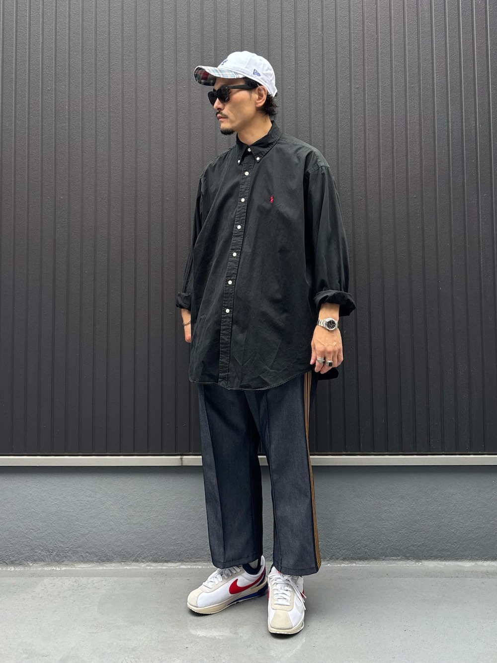 ブラック系のシャツ/ブラウス、ブルー系のパンツ、ホワイト系のスニーカーを着用したメンズの秋コーディネートの3枚目の写真