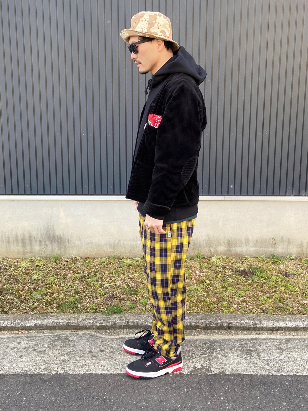 ブラック系のノーカラージャケット、ブラック系のパーカー、グリーン系のTシャツ/カットソーを着用したメンズの冬コーディネートの2枚目の写真