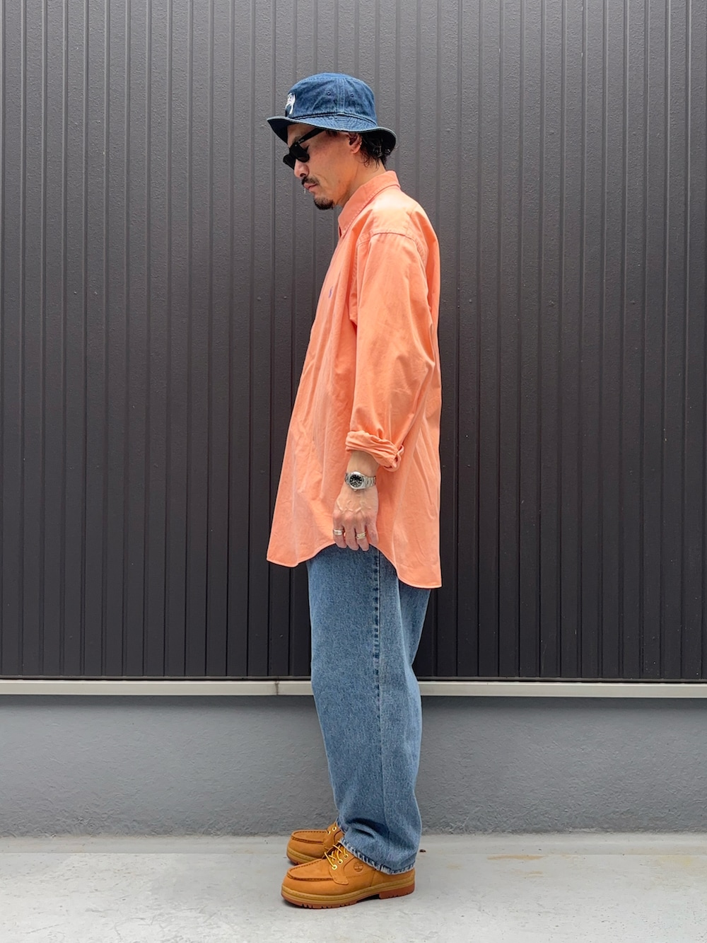 ピンク系のシャツ/ブラウス、ブルー系のデニムパンツ、イエロー系のブーツを着用したメンズの春コーディネートの2枚目の写真