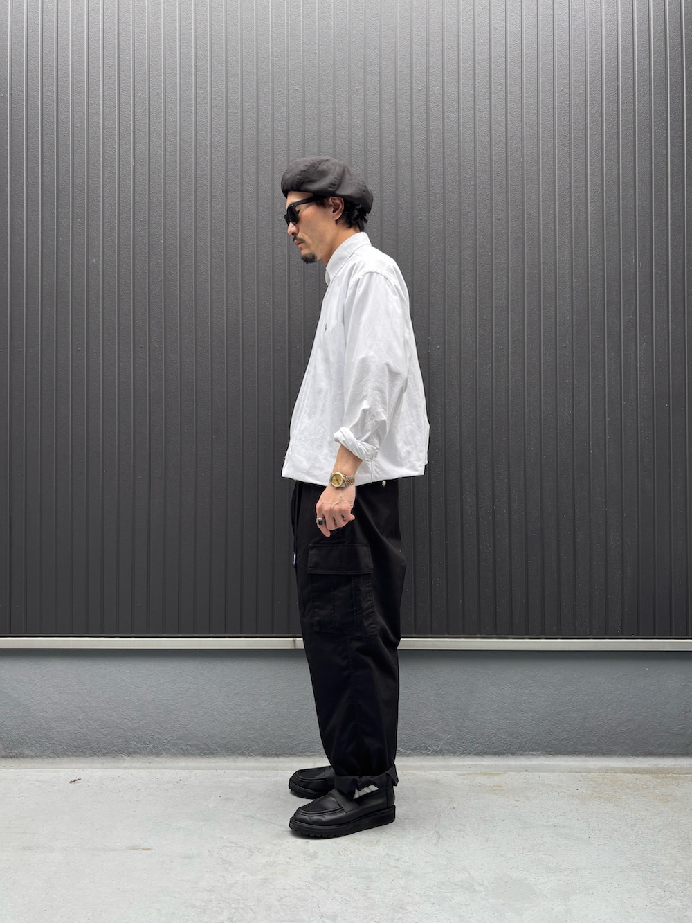 ホワイト系のシャツ/ブラウス、ブラック系のカーゴパンツ、ブラック系のシューズを着用したメンズの春コーディネートの2枚目の写真