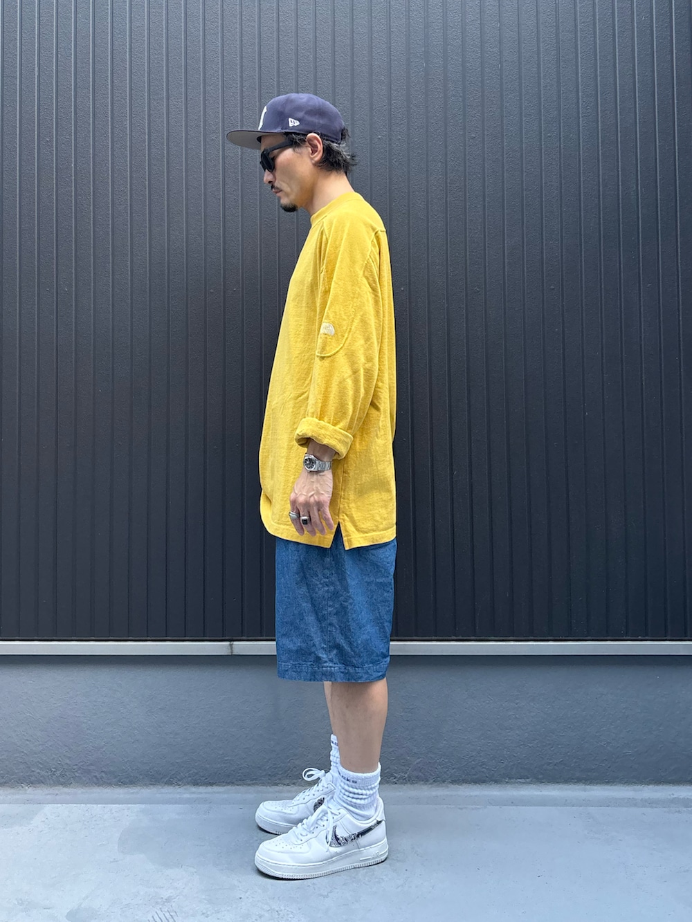 イエロー系のトップス、ブルー系のその他パンツ、ホワイト系のスニーカーを着用したメンズの秋コーディネートの2枚目の写真