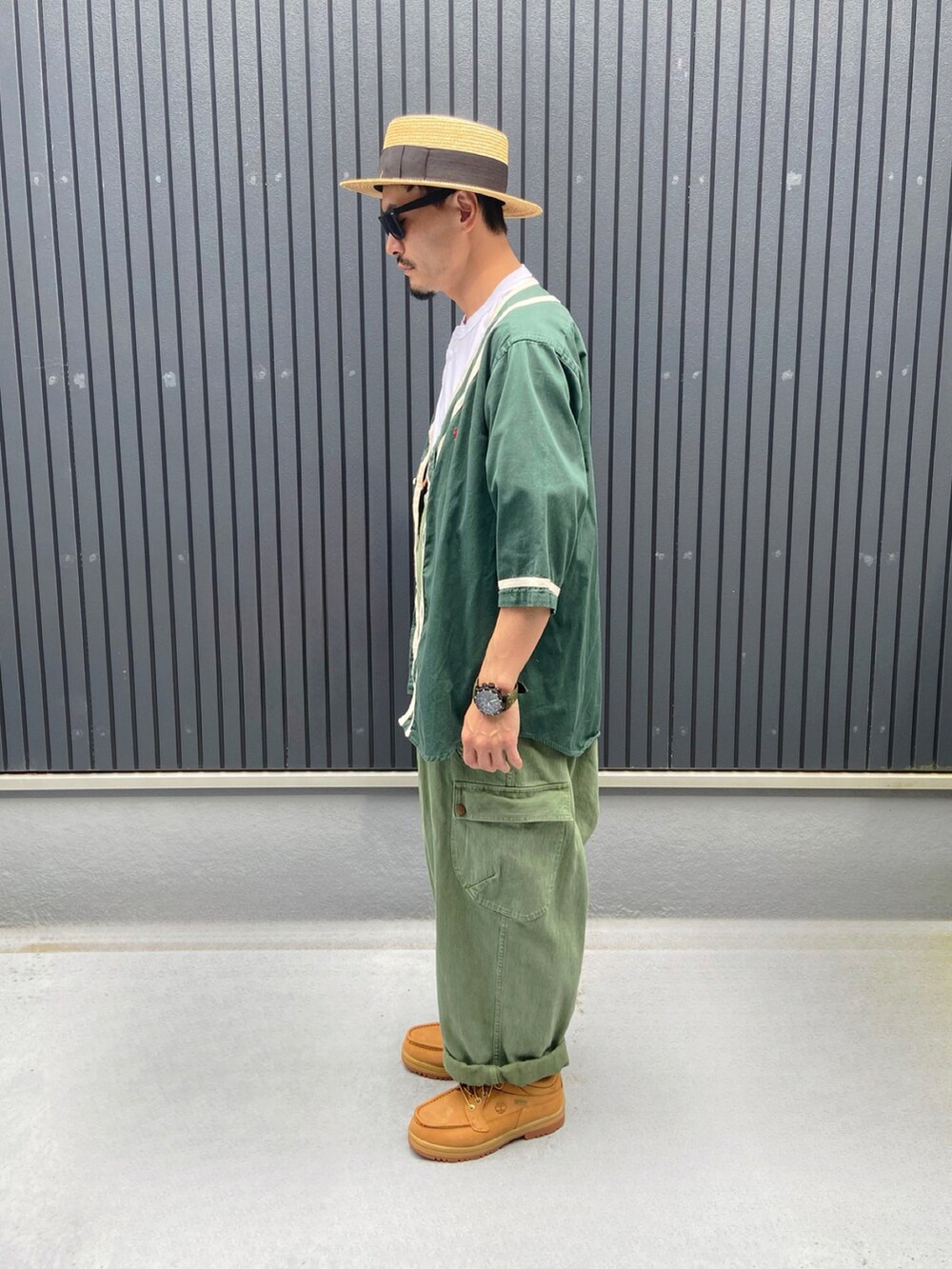 グリーン系のトップス、ホワイト系のTシャツ/カットソー、グリーン系のサロペット/オーバーオールを着用したメンズの夏コーディネートの2枚目の写真