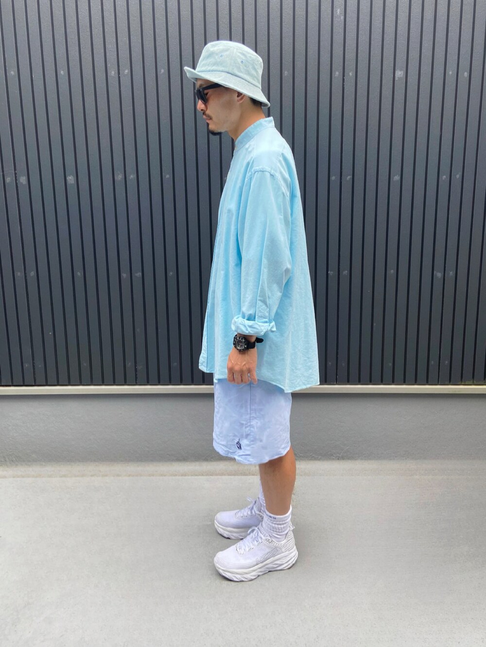 グリーン系のシャツ/ブラウス、ブルー系のその他パンツ、ホワイト系のスニーカーを着用したメンズの夏コーディネートの2枚目の写真