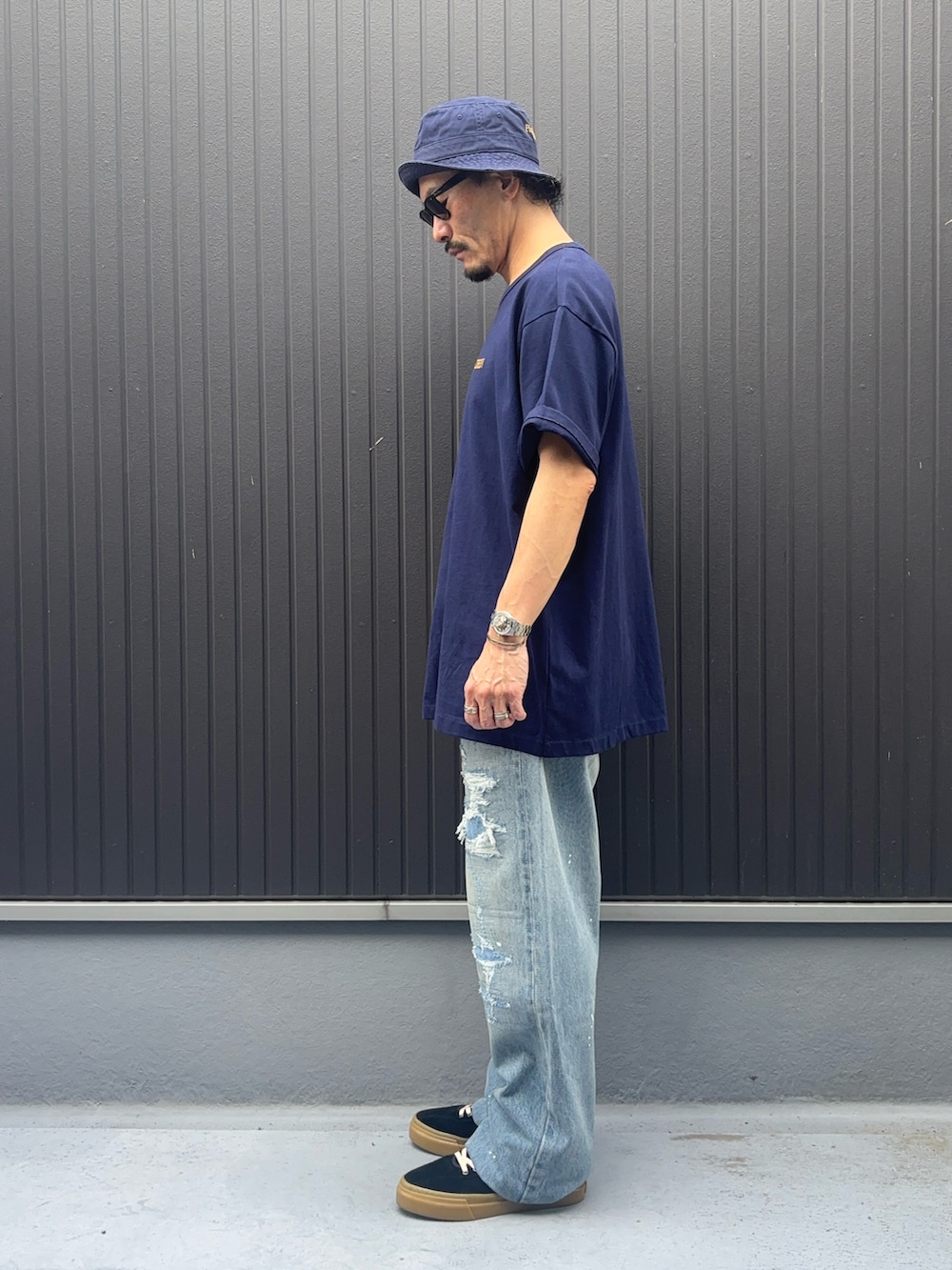 ブルー系のTシャツ/カットソー、ブルー系のデニムパンツ、ブラック系のスニーカーを着用したメンズの夏コーディネートの2枚目の写真