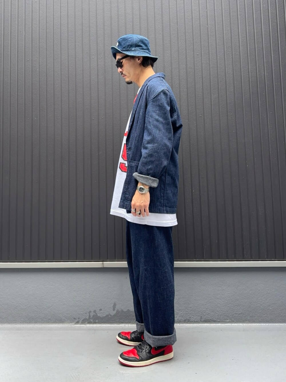 ホワイト系のタンクトップ、ブルー系のデニムジャケット、ブルー系のデニムパンツを着用したメンズの秋コーディネートの2枚目の写真
