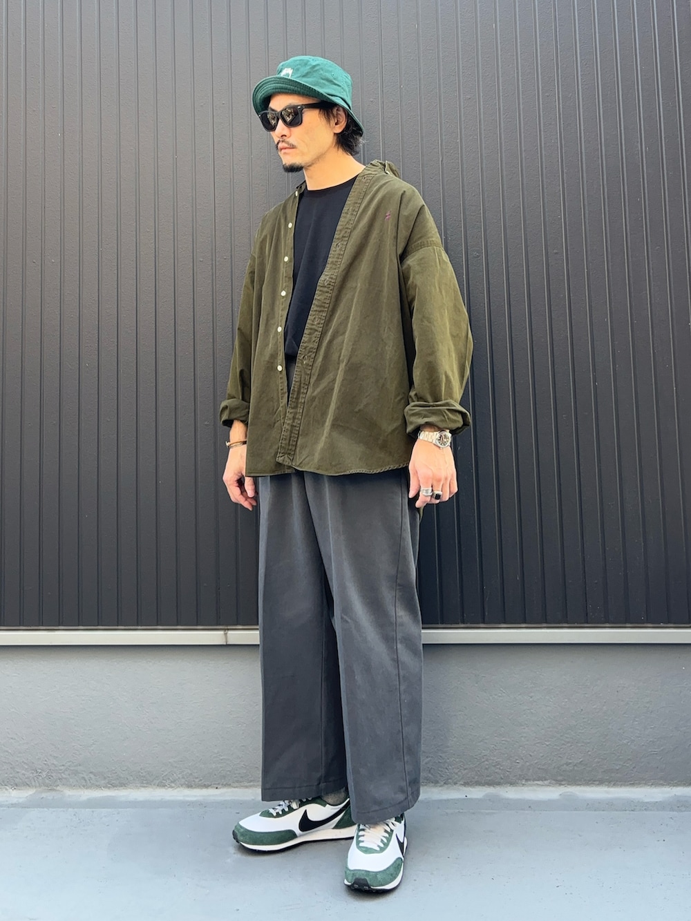 グリーン系のシャツ/ブラウス、ブラック系のTシャツ/カットソー、グレー系のパンツを着用したメンズの秋コーディネートの3枚目の写真