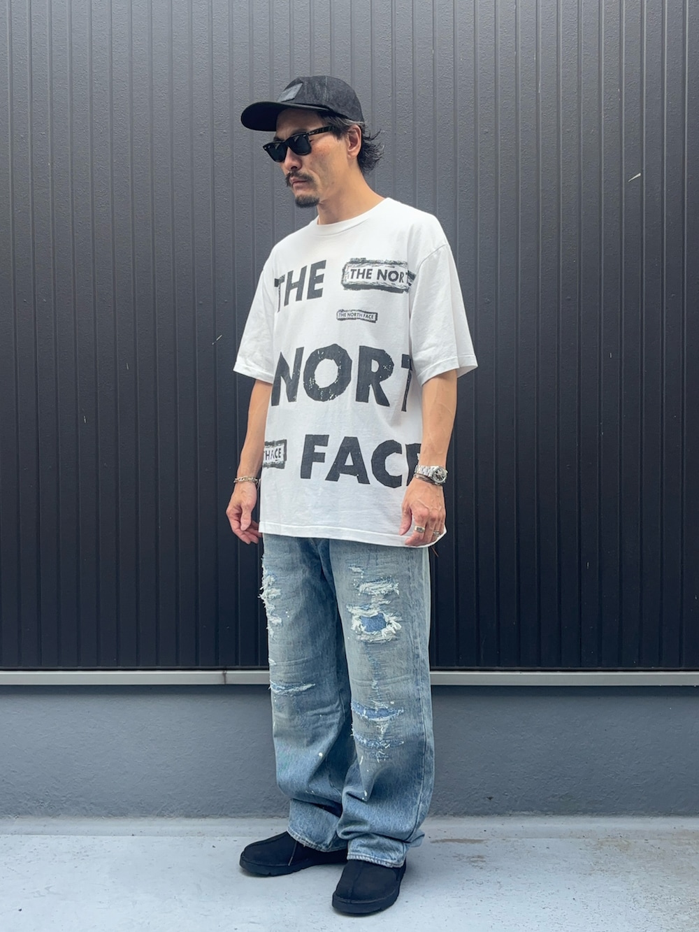 ホワイト系のTシャツ/カットソー、ブルー系のモカシン/デッキシューズ、ブルー系のデニムパンツを着用したメンズの秋コーディネートの3枚目の写真