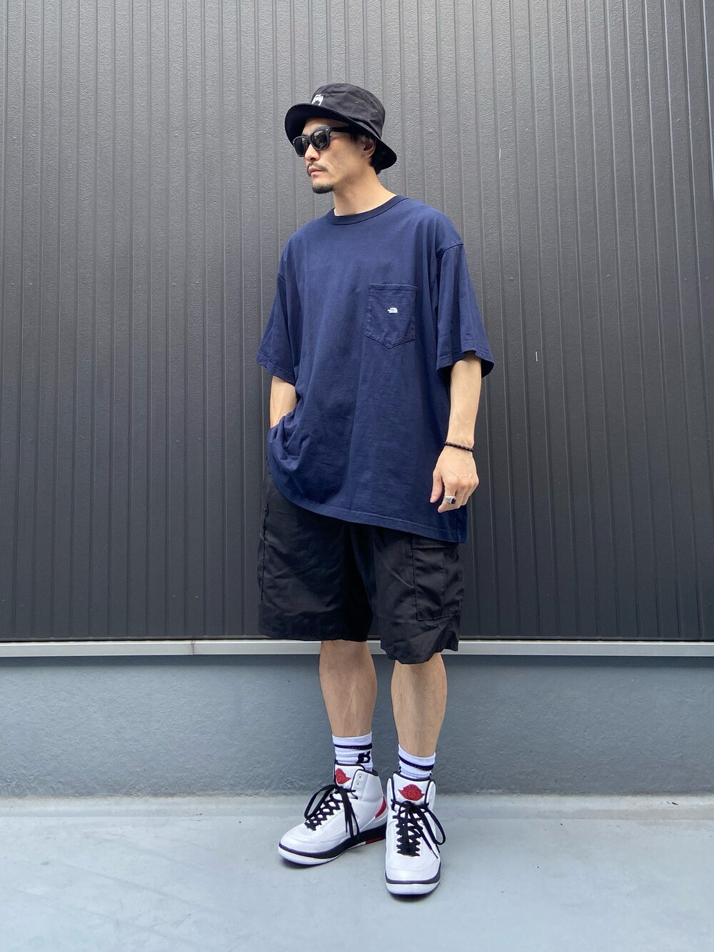 ブルー系のTシャツ/カットソー、ブラック系のパンツ、ホワイト系のスニーカーを着用したメンズの夏コーディネートの3枚目の写真