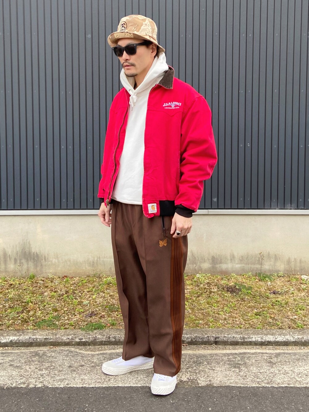レッド系のジャケット/アウター、ホワイト系のパーカー、ブラウン系のパンツを着用したメンズの冬コーディネートの3枚目の写真