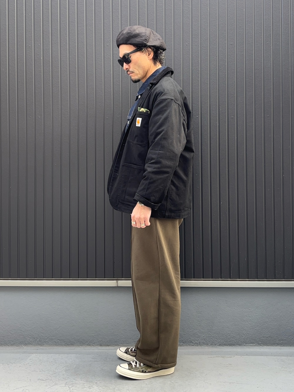 ブラック系のジャケット/アウター、ブルー系のデニムジャケット、グリーン系のスウェットパンツを着用したメンズの春コーディネートの2枚目の写真