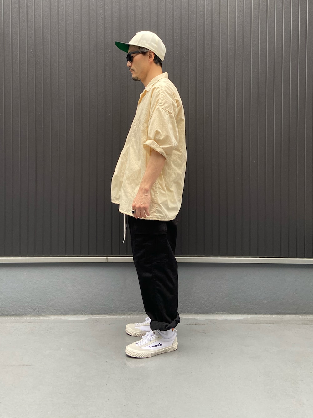 ベージュ系のトップス、ホワイト系のTシャツ/カットソー、ブラック系のカーゴパンツを着用したメンズの夏コーディネートの2枚目の写真