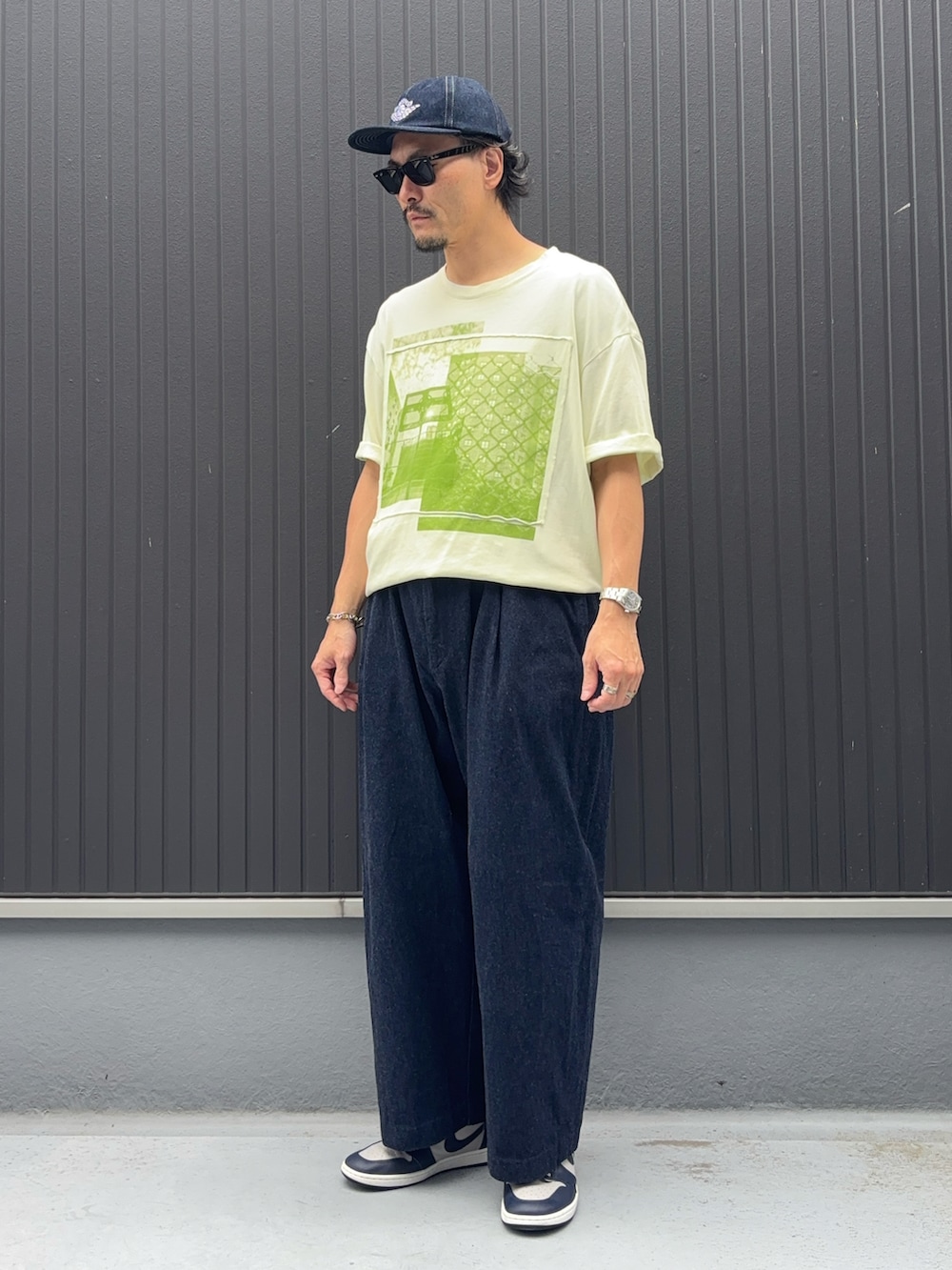 イエロー系のTシャツ/カットソー、ブルー系のデニムパンツ、グレー系のスニーカーを着用したメンズの秋コーディネートの4枚目の写真