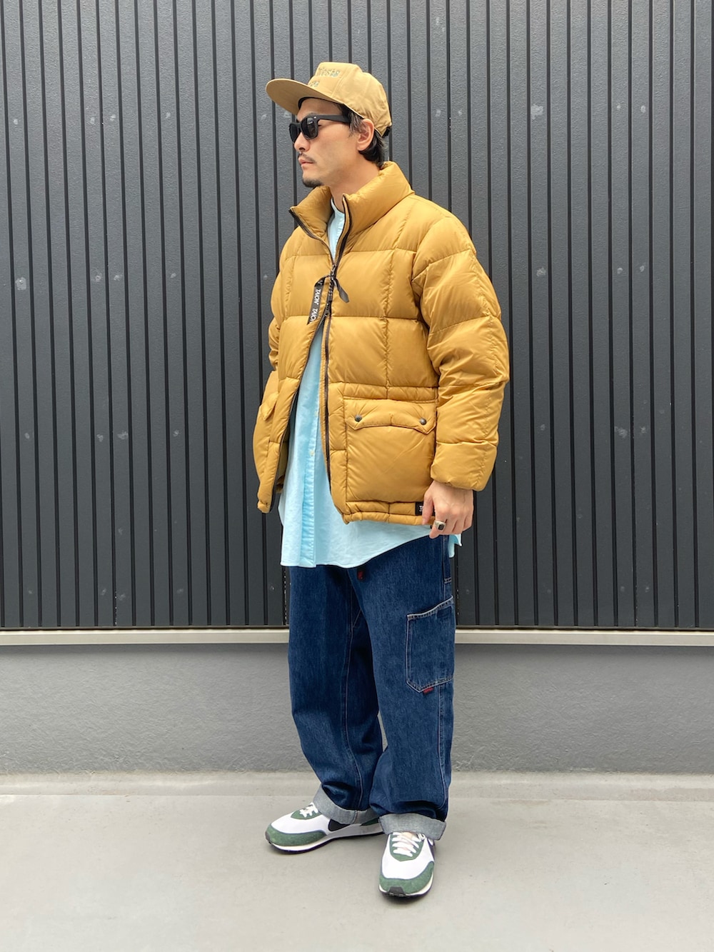 ベージュ系のダウンジャケット/コート、グリーン系のシャツ/ブラウス、ブルー系のデニムパンツを着用したメンズの冬コーディネートの3枚目の写真