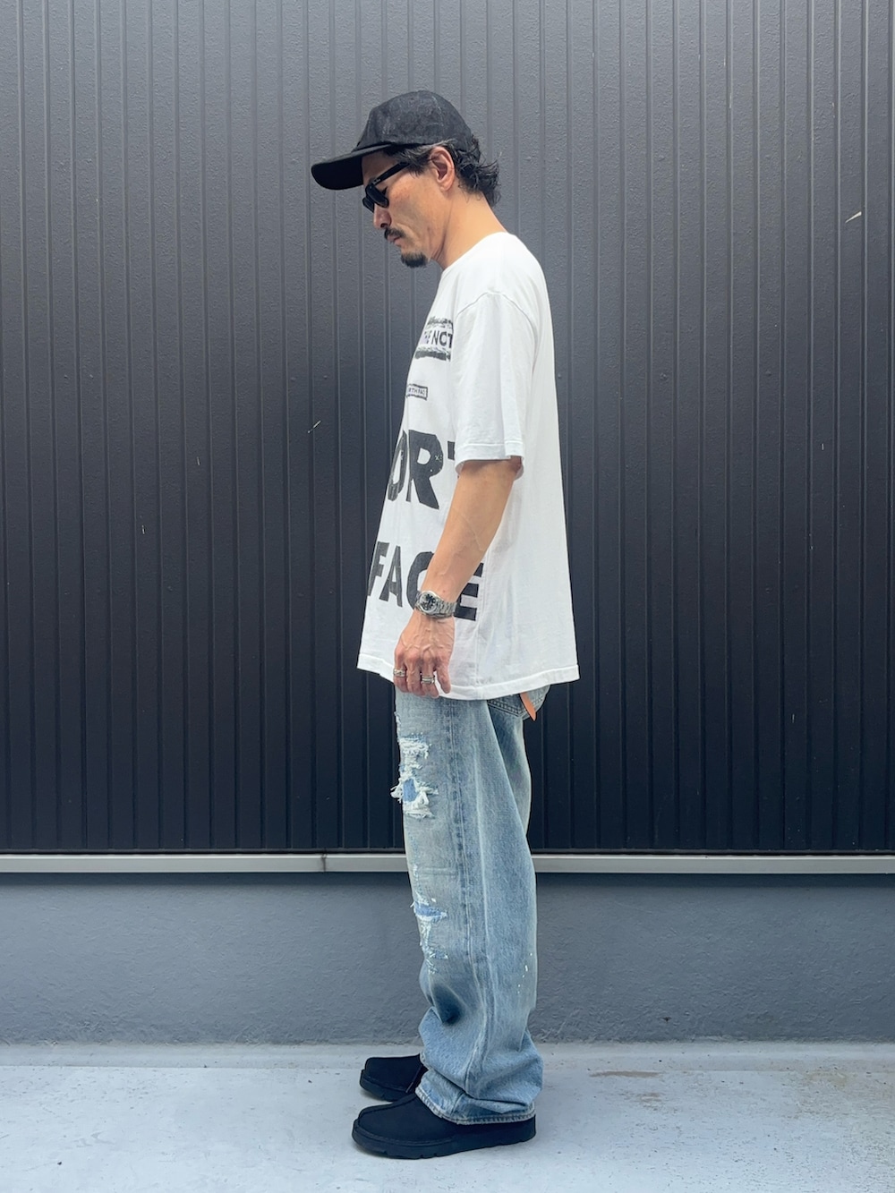 ホワイト系のTシャツ/カットソー、ブルー系のモカシン/デッキシューズ、ブルー系のデニムパンツを着用したメンズの秋コーディネートの2枚目の写真