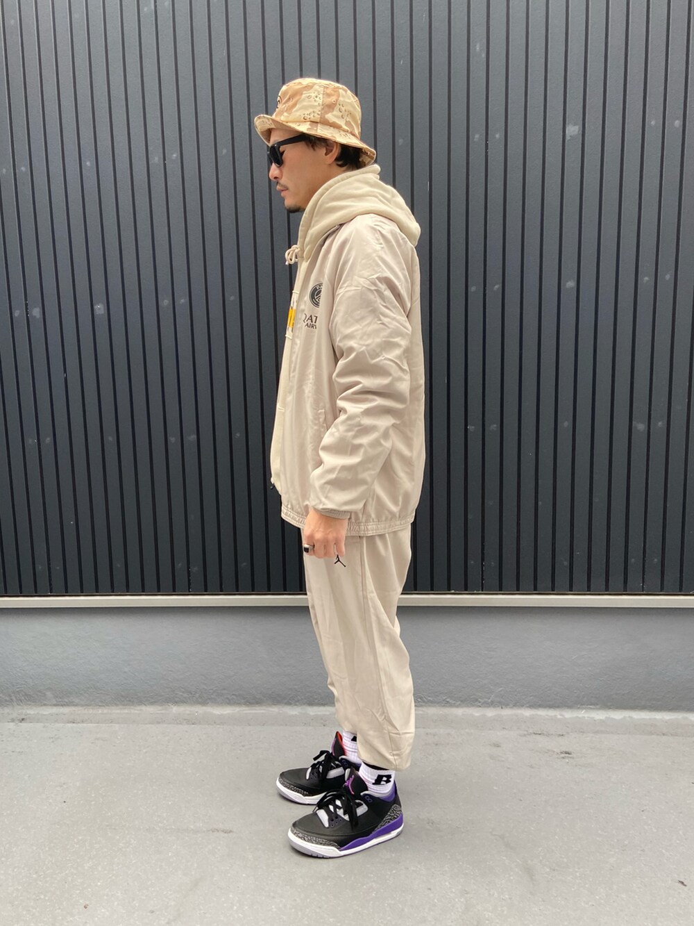 グレー系のスーツセット、ベージュ系のパーカー、ベージュ系のパーカーを着用したメンズの冬コーディネートの2枚目の写真