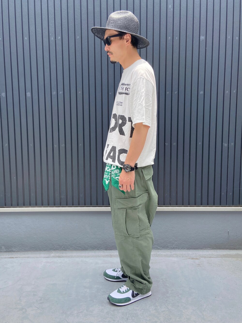 ホワイト系のTシャツ/カットソー、グリーン系のパンツ、グリーン系のスニーカーを着用したメンズの夏コーディネートの2枚目の写真