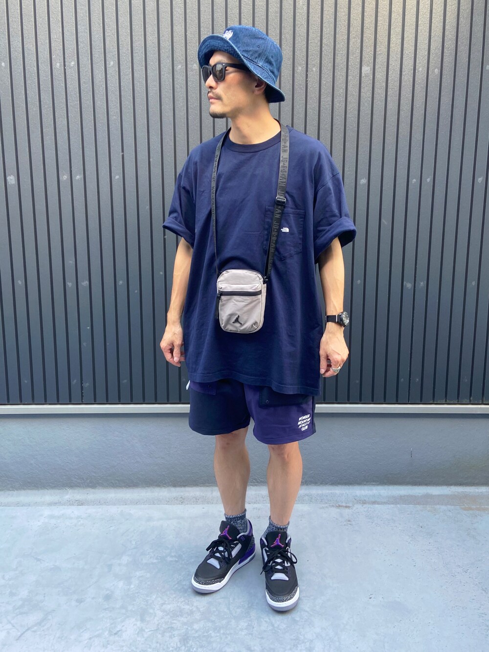 グレー系のバッグ、ブルー系のTシャツ/カットソー、ブルー系のパンツを着用したメンズの秋コーディネートの3枚目の写真