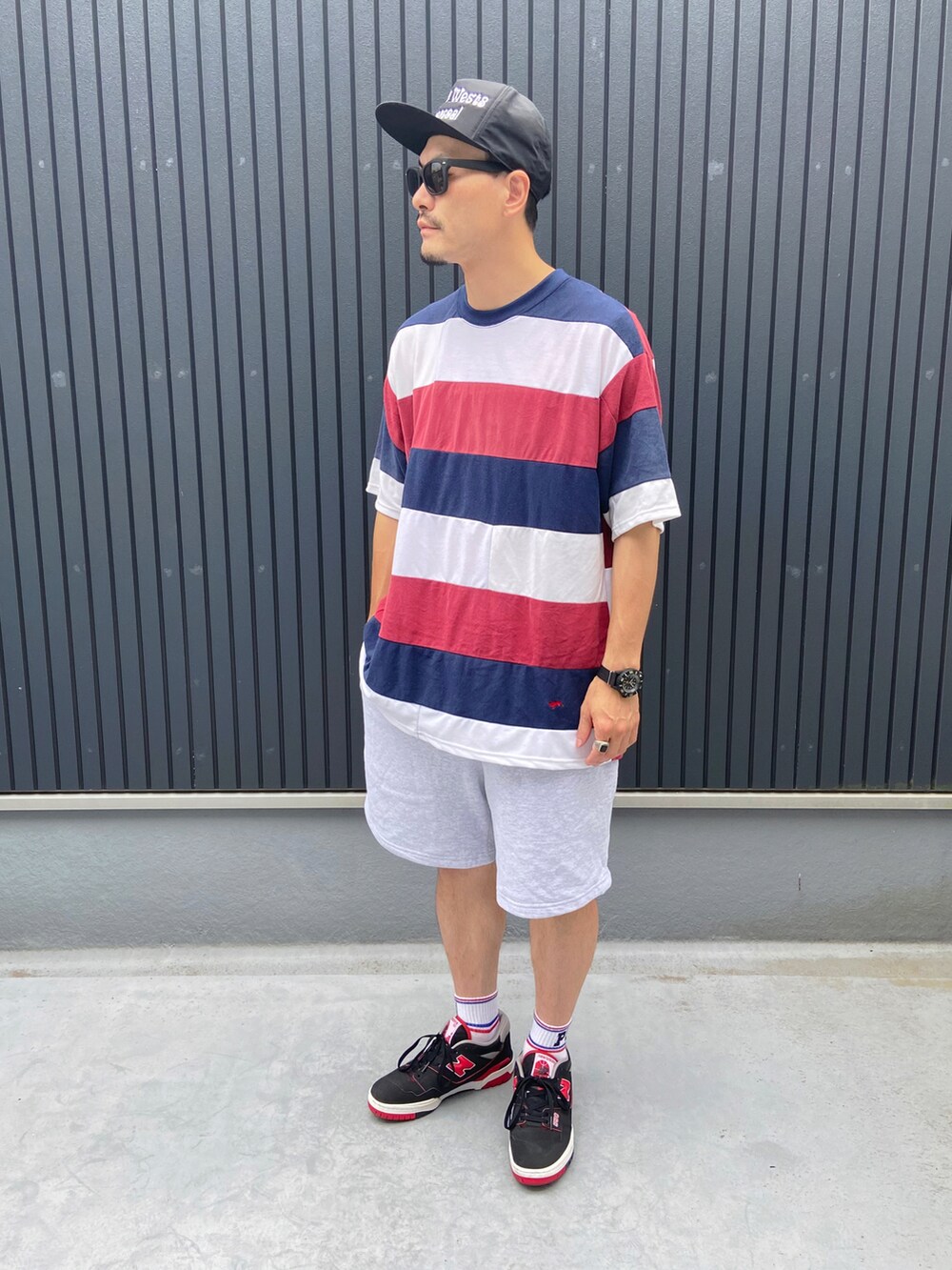 その他のTシャツ/カットソー、グレー系のパンツ、ブラック系のスニーカーを着用したメンズの夏コーディネートの3枚目の写真