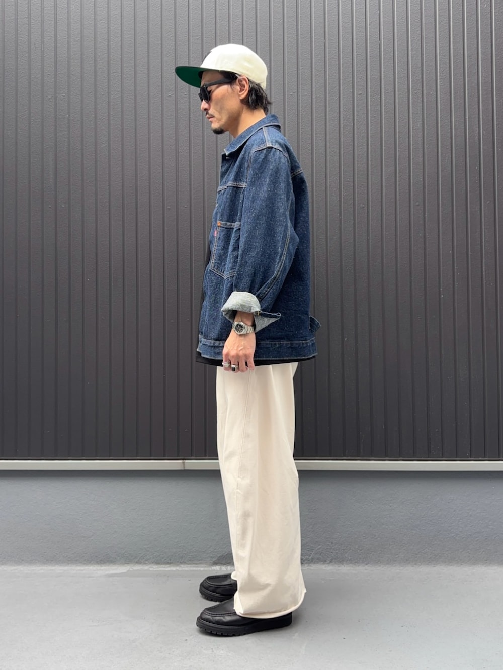 ブラック系のTシャツ/カットソー、ブルー系のデニムジャケット、ホワイト系のスウェットパンツを着用したメンズの秋コーディネートの2枚目の写真