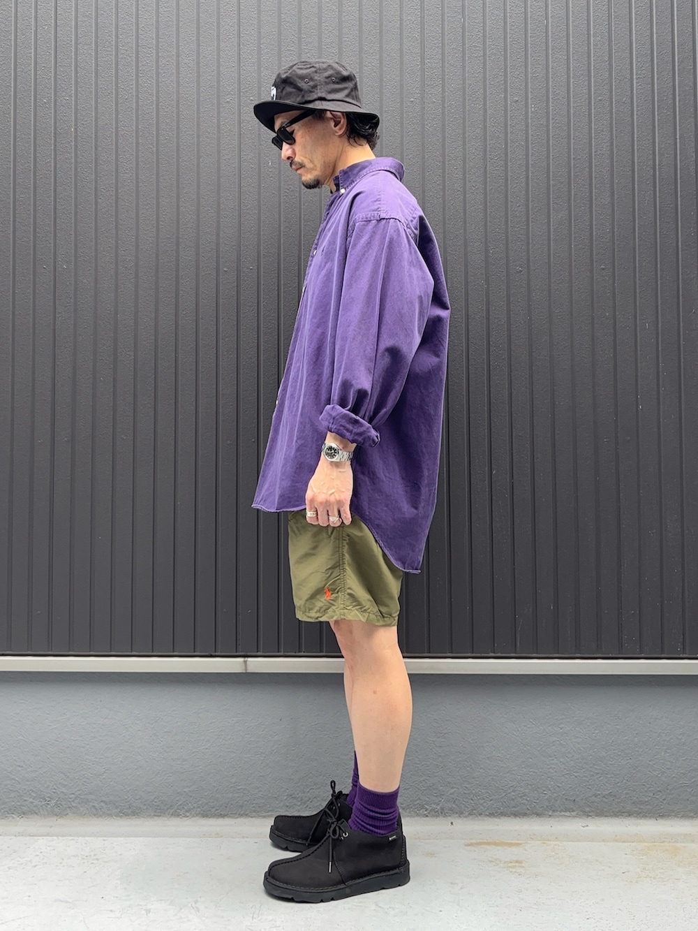 ブルー系のモカシン/デッキシューズ、パープル系のシャツ/ブラウス、グリーン系のパンツを着用したメンズの夏コーディネートの2枚目の写真