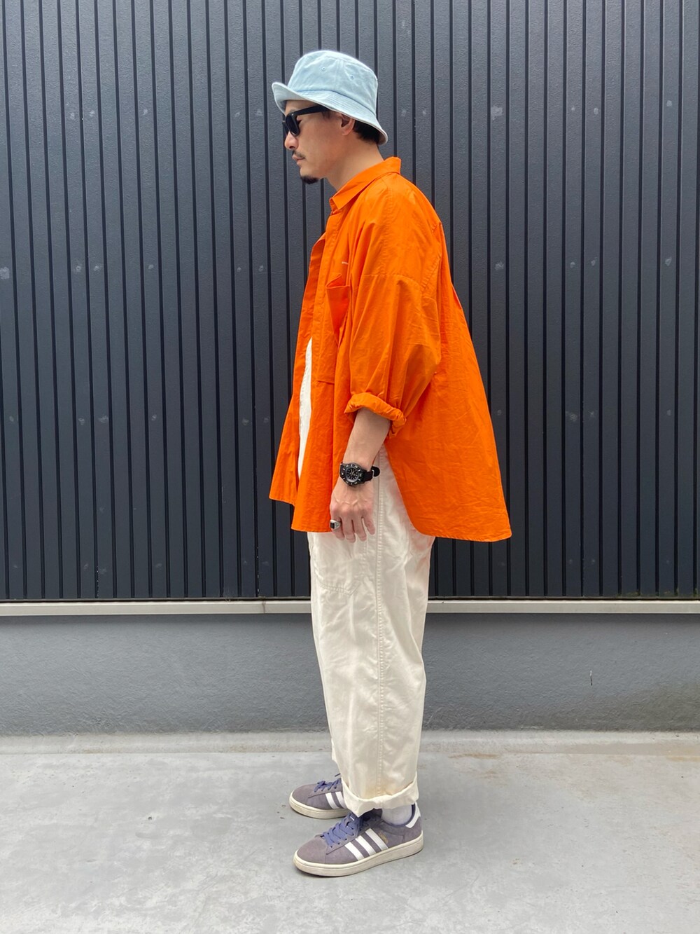 オレンジ系のトップス、その他のTシャツ/カットソー、ホワイト系のサロペット/オーバーオールを着用したメンズの夏コーディネートの2枚目の写真