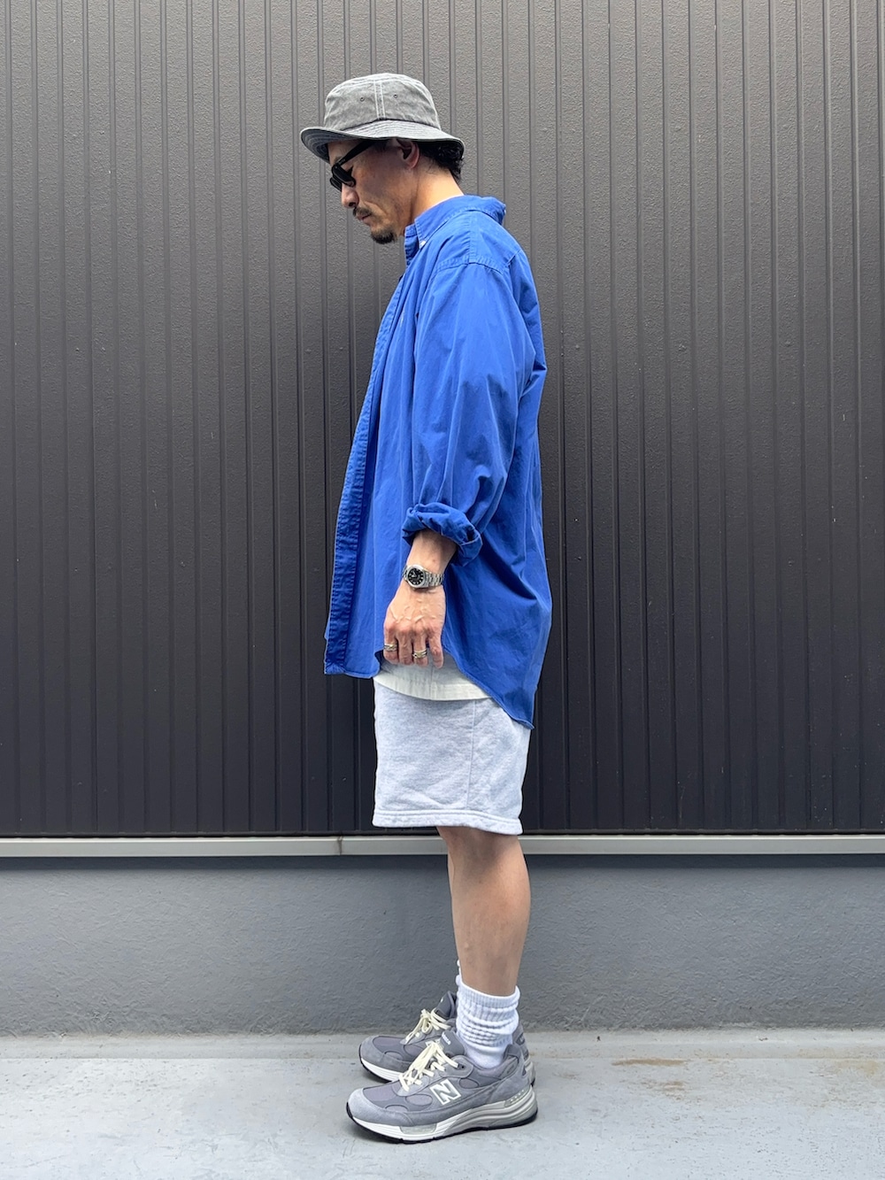ブルー系のシャツ/ブラウス、ホワイト系のTシャツ/カットソー、グレー系のパンツを着用したメンズの夏コーディネートの2枚目の写真