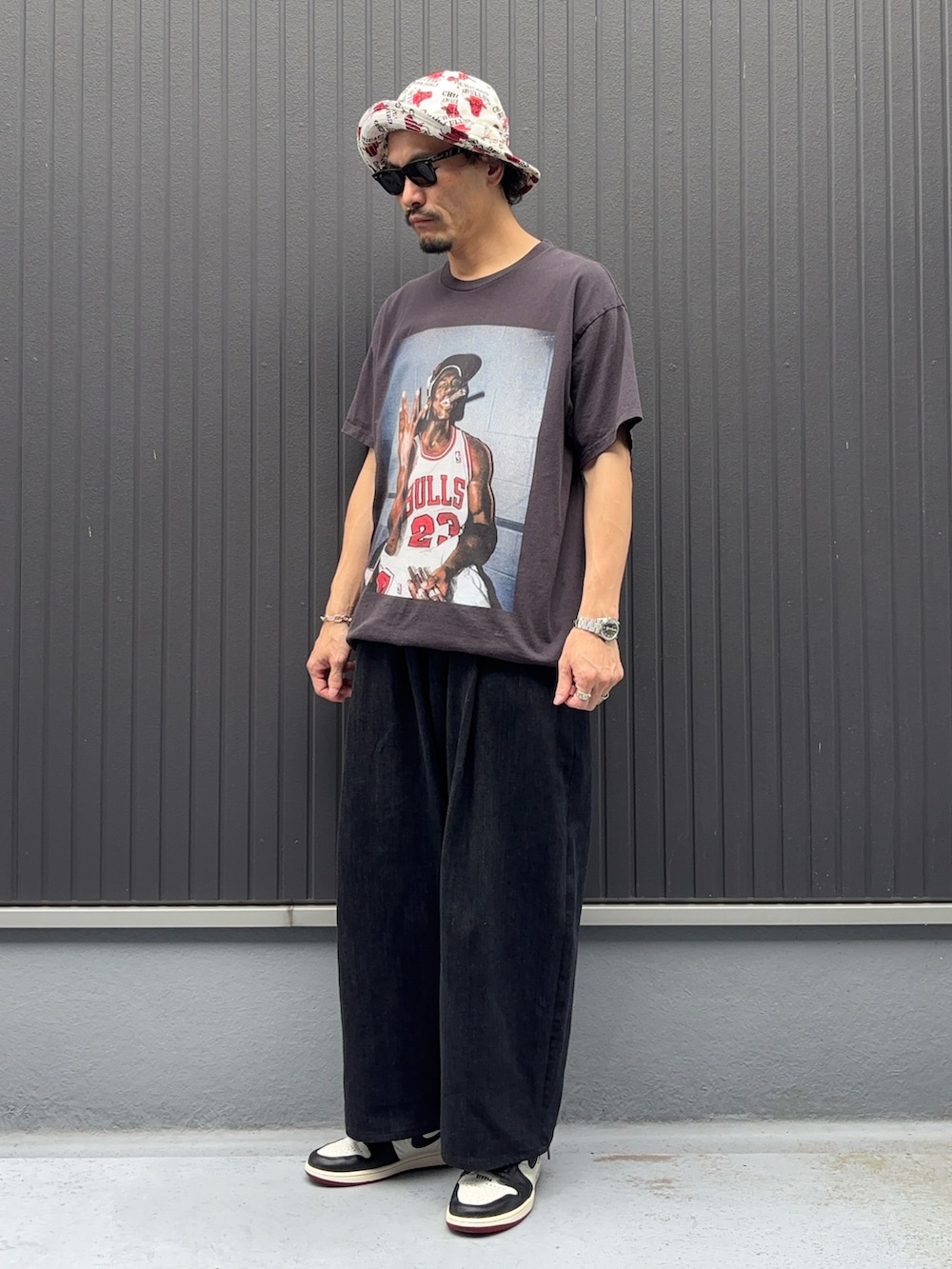 ブラック系のTシャツ/カットソー、ブラック系のデニムパンツ、ホワイト系のスニーカーを着用したメンズの夏コーディネートの3枚目の写真
