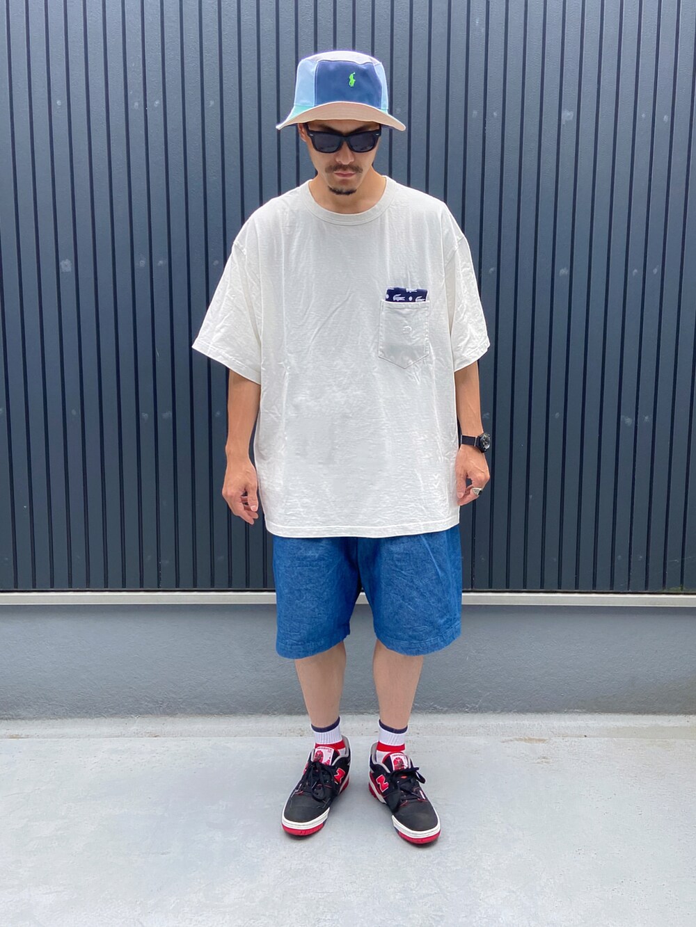 ホワイト系のTシャツ/カットソー、ブルー系のその他パンツ、ブラック系のスニーカーを着用したメンズの夏コーディネートの3枚目の写真