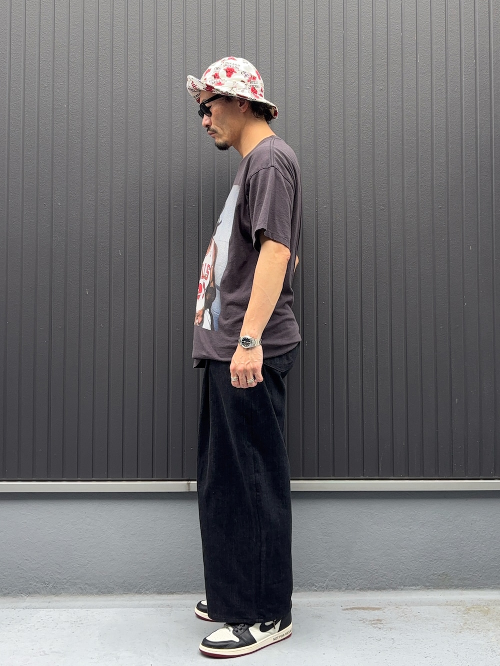 ブラック系のTシャツ/カットソー、ブラック系のデニムパンツ、ホワイト系のスニーカーを着用したメンズの夏コーディネートの2枚目の写真