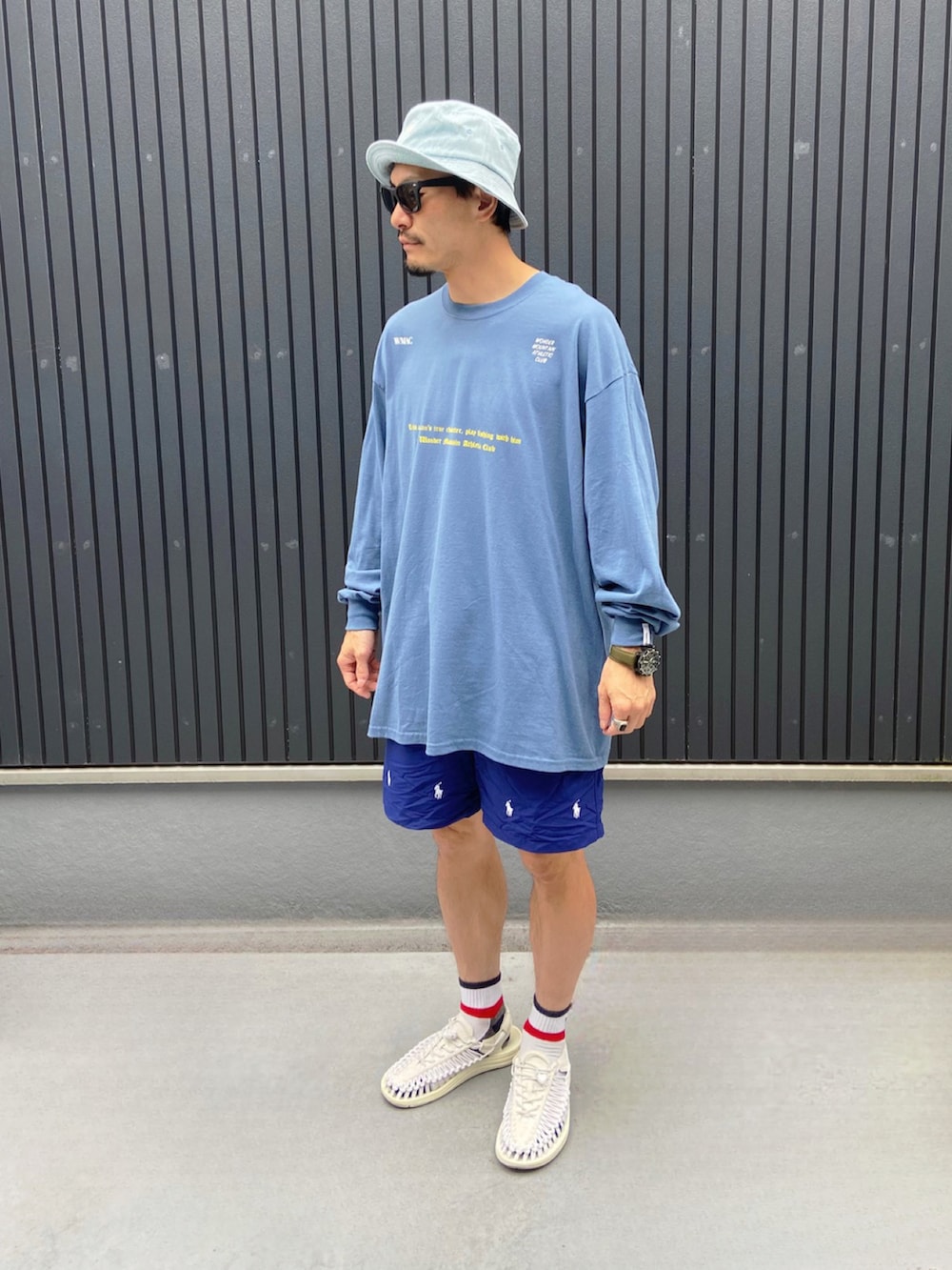 ブルー系のTシャツ/カットソー、ホワイト系のサンダル、ブルー系のハットを着用したメンズの夏コーディネートの3枚目の写真