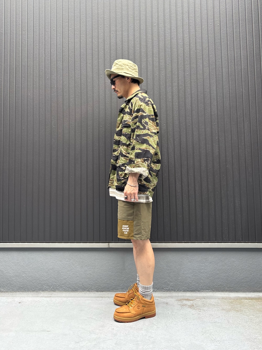 グリーン系のジャケット/アウター、ベージュ系のTシャツ/カットソー、ベージュ系のパンツを着用したメンズの夏コーディネートの2枚目の写真