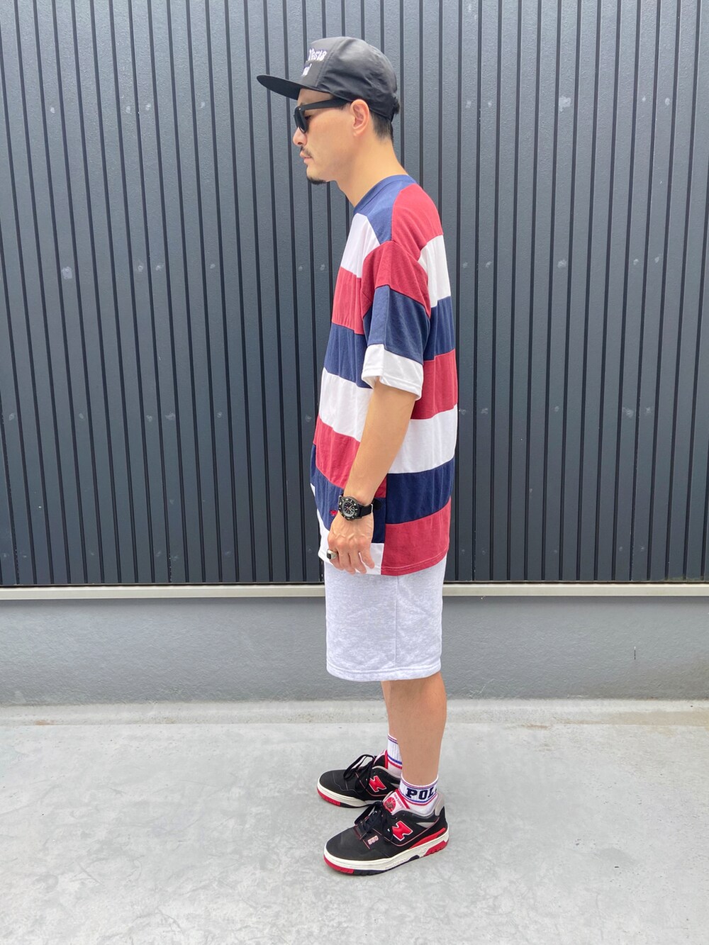 その他のTシャツ/カットソー、グレー系のパンツ、ブラック系のスニーカーを着用したメンズの夏コーディネートの2枚目の写真