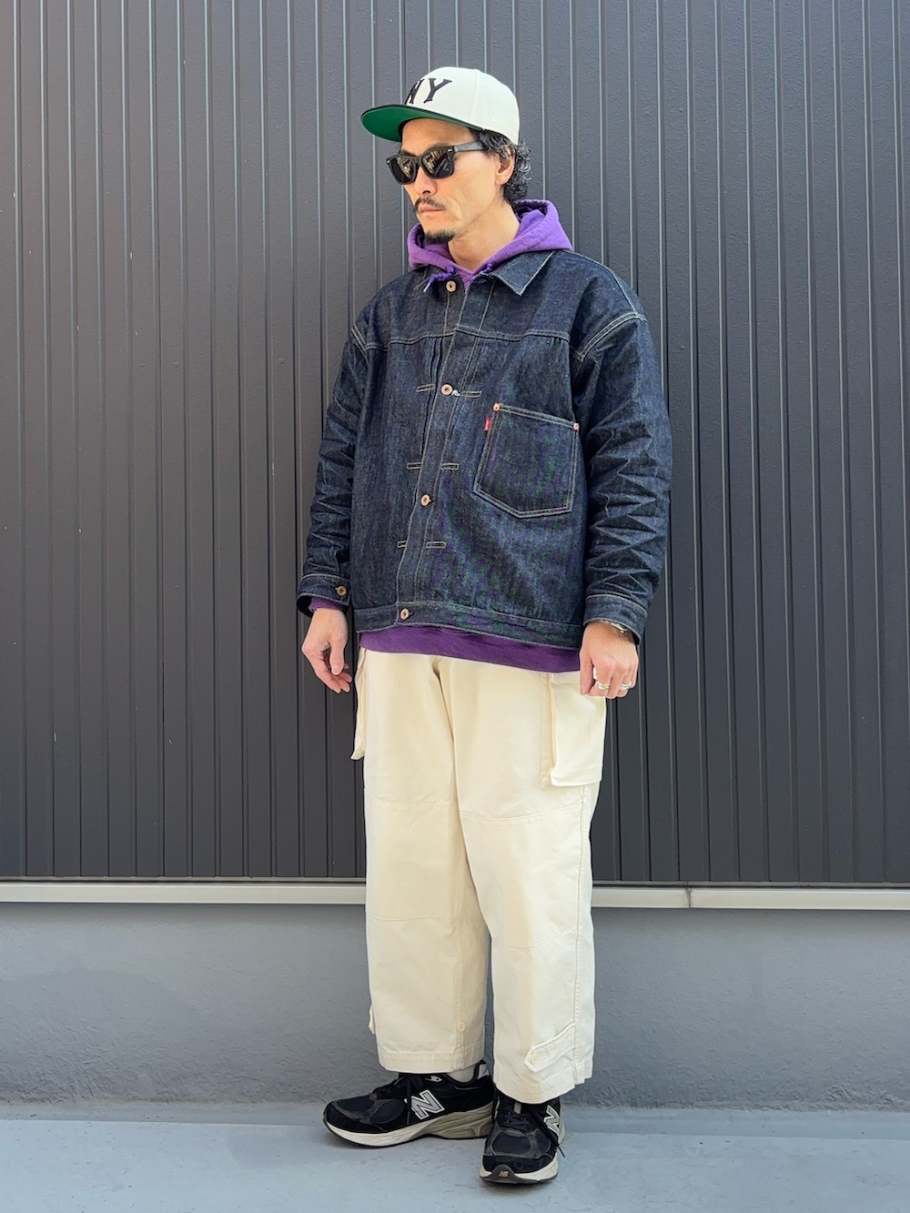 パープル系のパーカー、ブラック系のスニーカー、ブルー系のデニムジャケットを着用したメンズの冬コーディネートの3枚目の写真