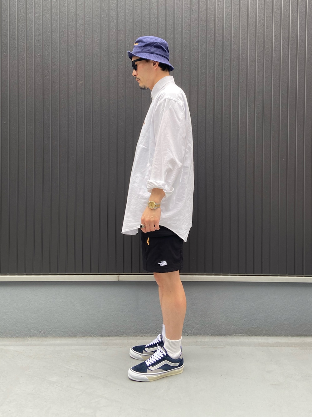 ホワイト系のシャツ/ブラウス、ブラック系のパンツ、ブルー系のスニーカーを着用したメンズの春コーディネートの2枚目の写真