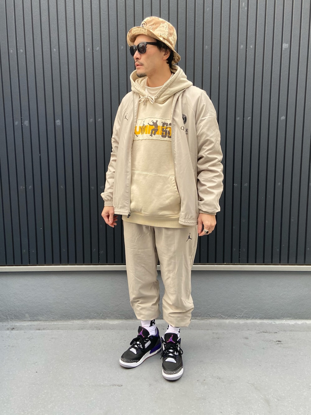 グレー系のスーツセット、ベージュ系のパーカー、ベージュ系のパーカーを着用したメンズの冬コーディネートの3枚目の写真