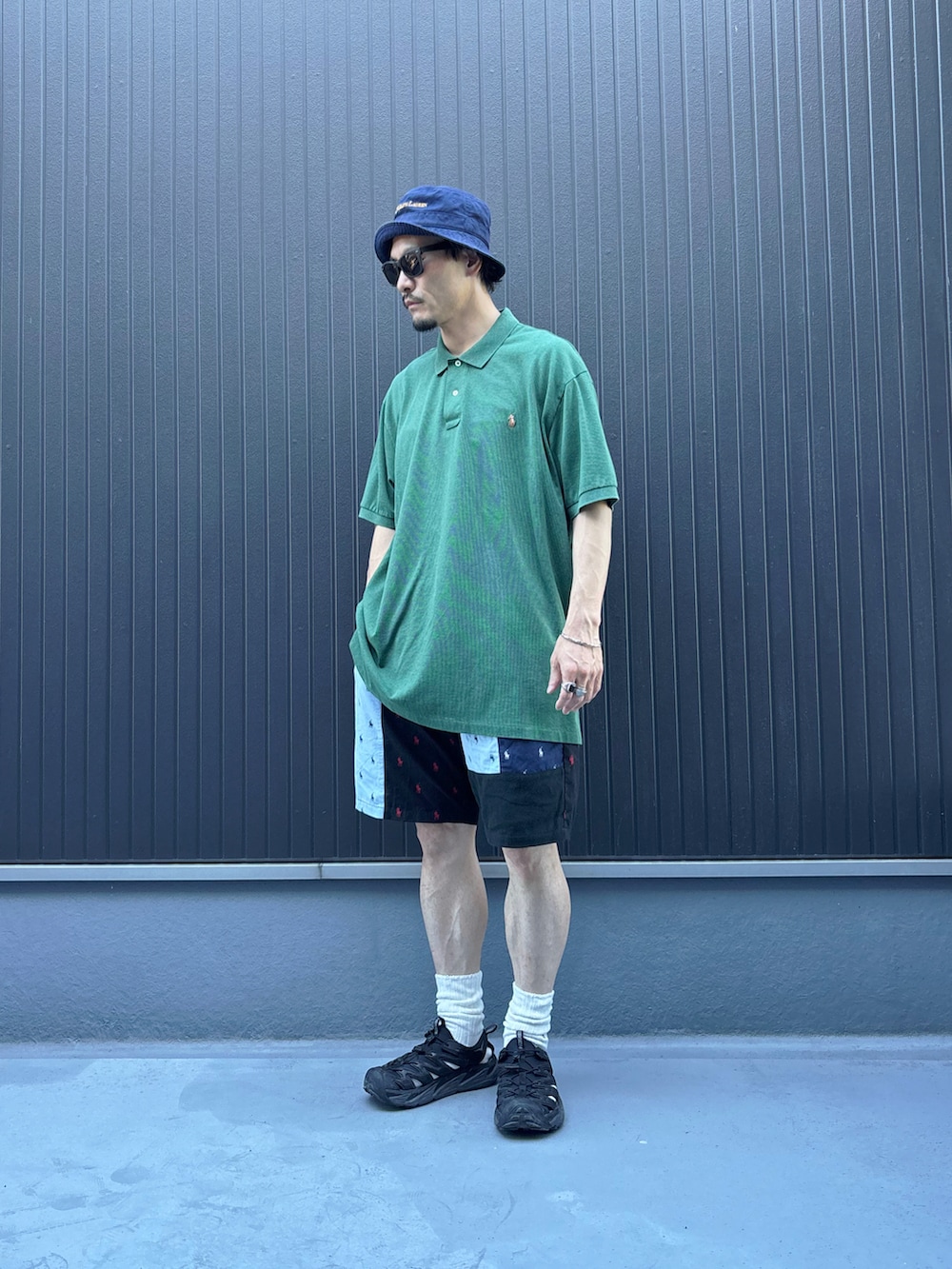 グリーン系のポロシャツ、その他のパンツ、ブラック系のサンダルを着用したメンズの夏コーディネートの3枚目の写真