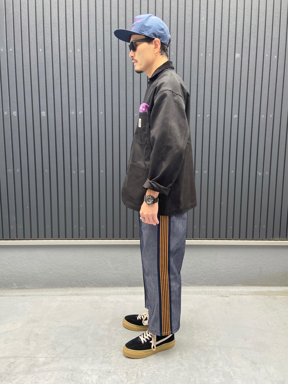 ブラック系のジャケット/アウター、パープル系のポロシャツ、ブルー系のパンツを着用したメンズの秋コーディネートの2枚目の写真