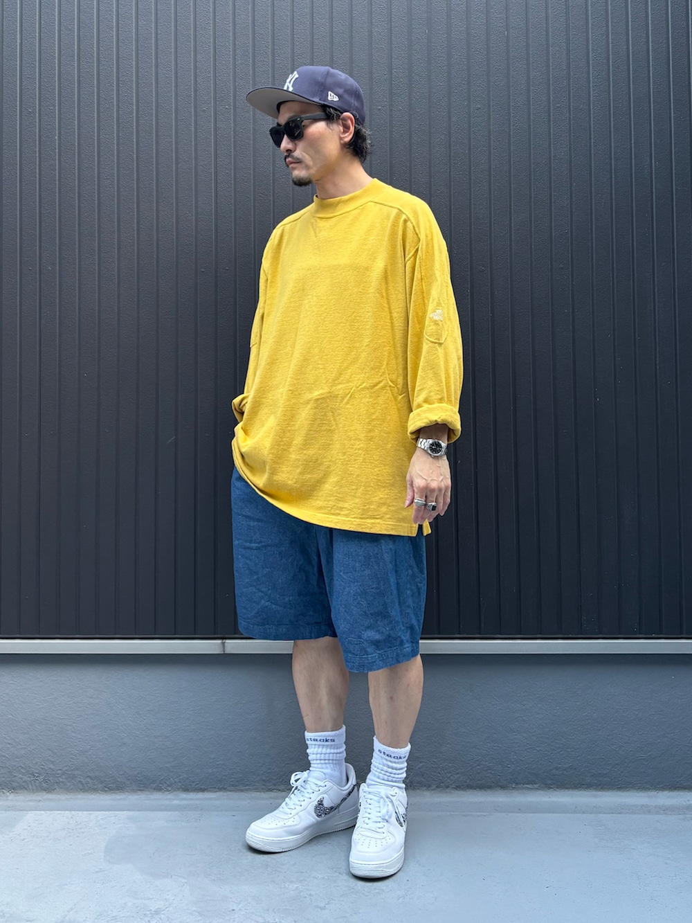 イエロー系のトップス、ブルー系のその他パンツ、ホワイト系のスニーカーを着用したメンズの秋コーディネートの3枚目の写真