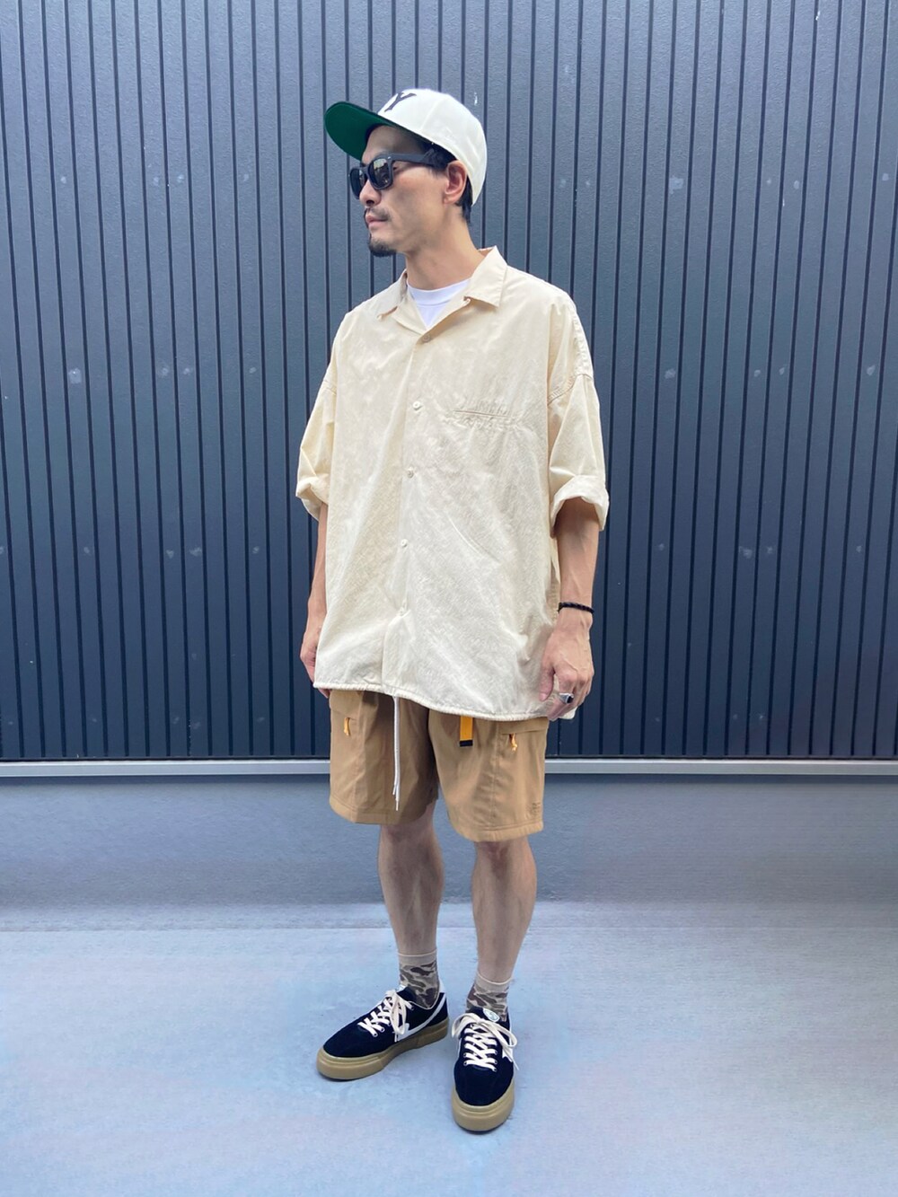 ベージュ系のトップス、ホワイト系のTシャツ/カットソー、ベージュ系のパンツを着用したメンズの夏コーディネートの3枚目の写真