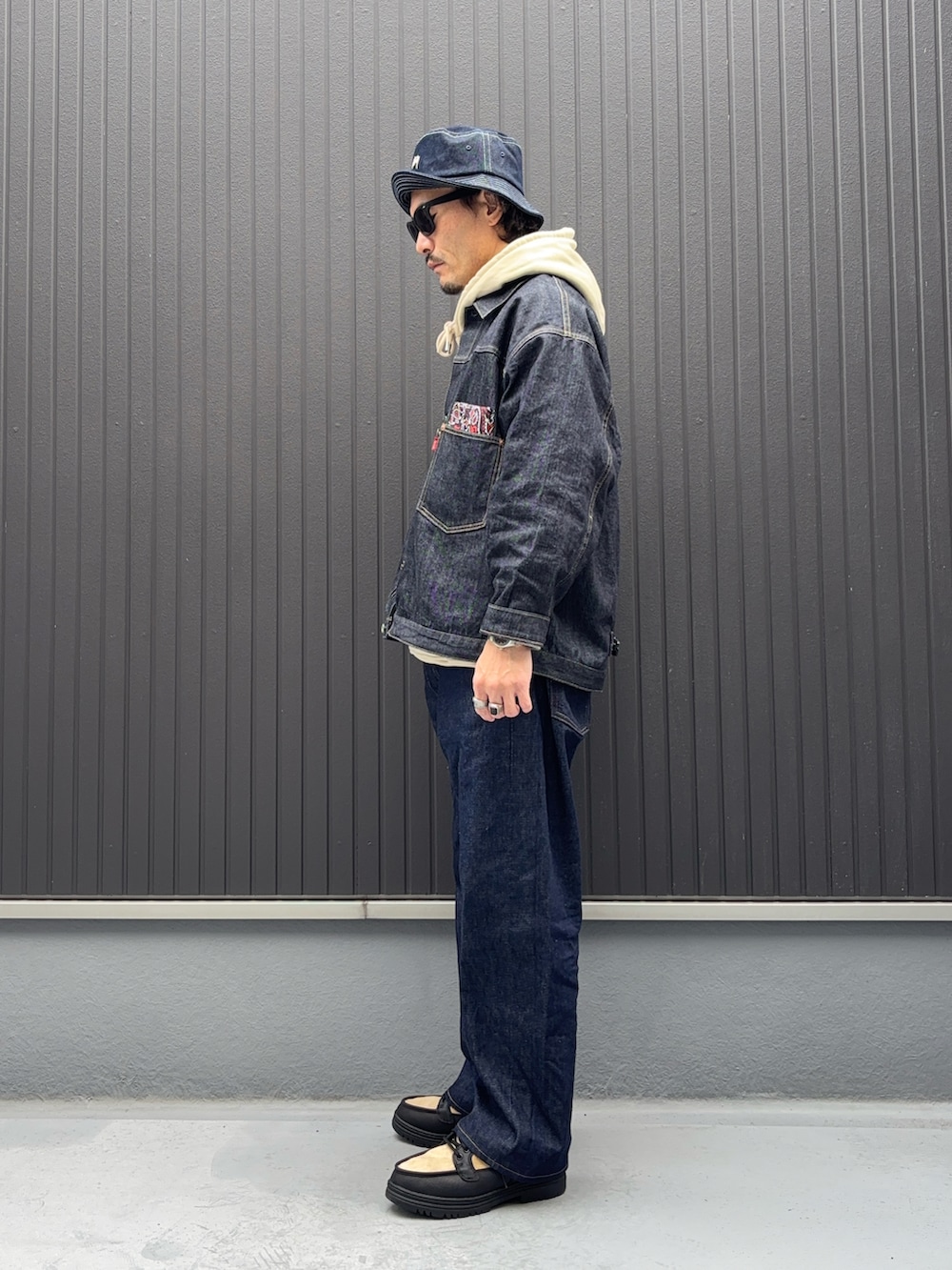 ベージュ系のパーカー、ベージュ系のパーカー、ブルー系のデニムジャケットを着用したメンズの秋コーディネートの2枚目の写真