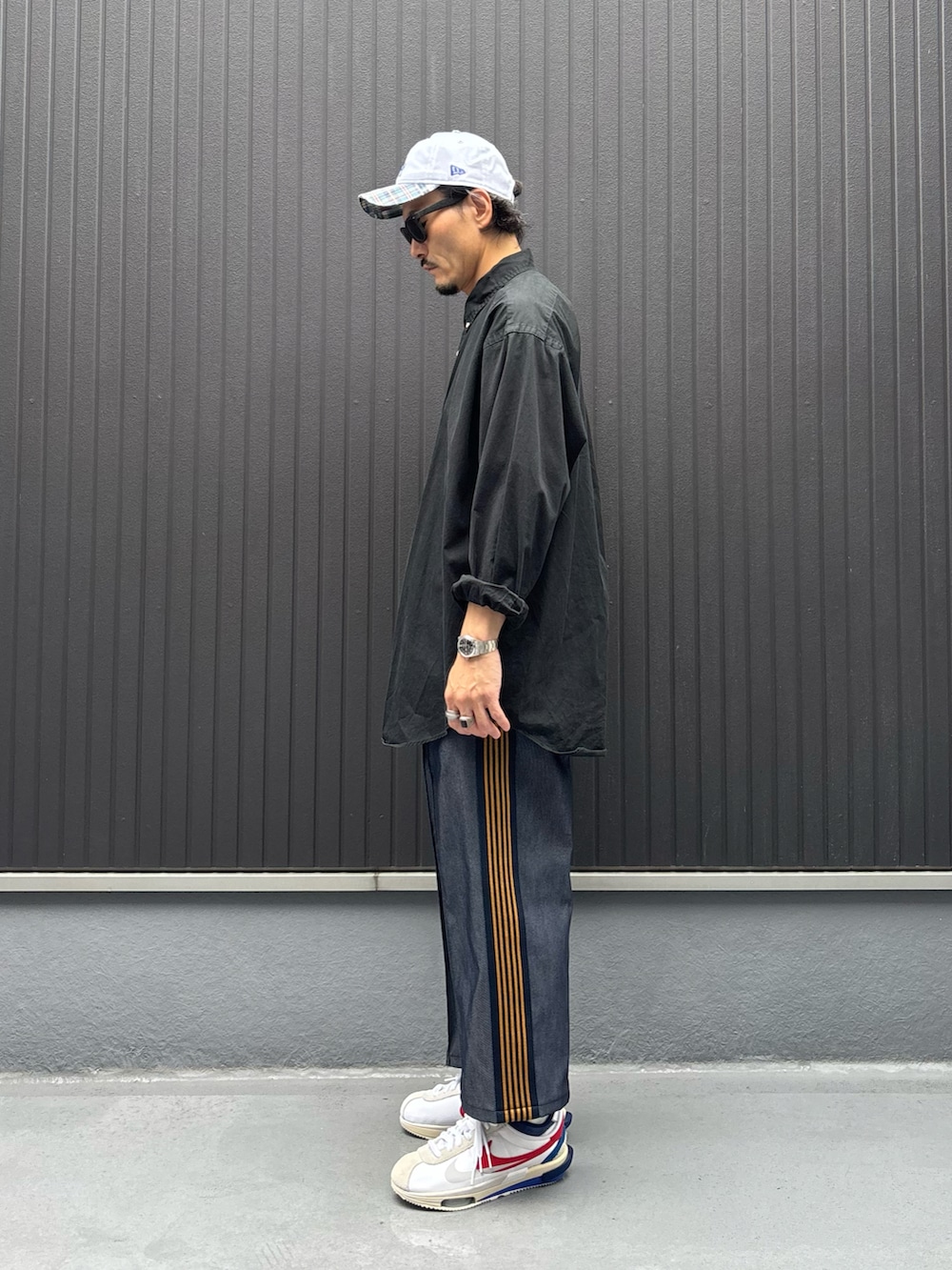 ブラック系のシャツ/ブラウス、ブルー系のパンツ、ホワイト系のスニーカーを着用したメンズの秋コーディネートの2枚目の写真