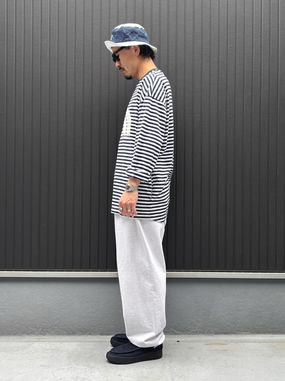 ブルー系のスニーカー、その他のTシャツ/カットソー、グレー系のスウェットパンツを着用したメンズの春コーディネートの2枚目の写真
