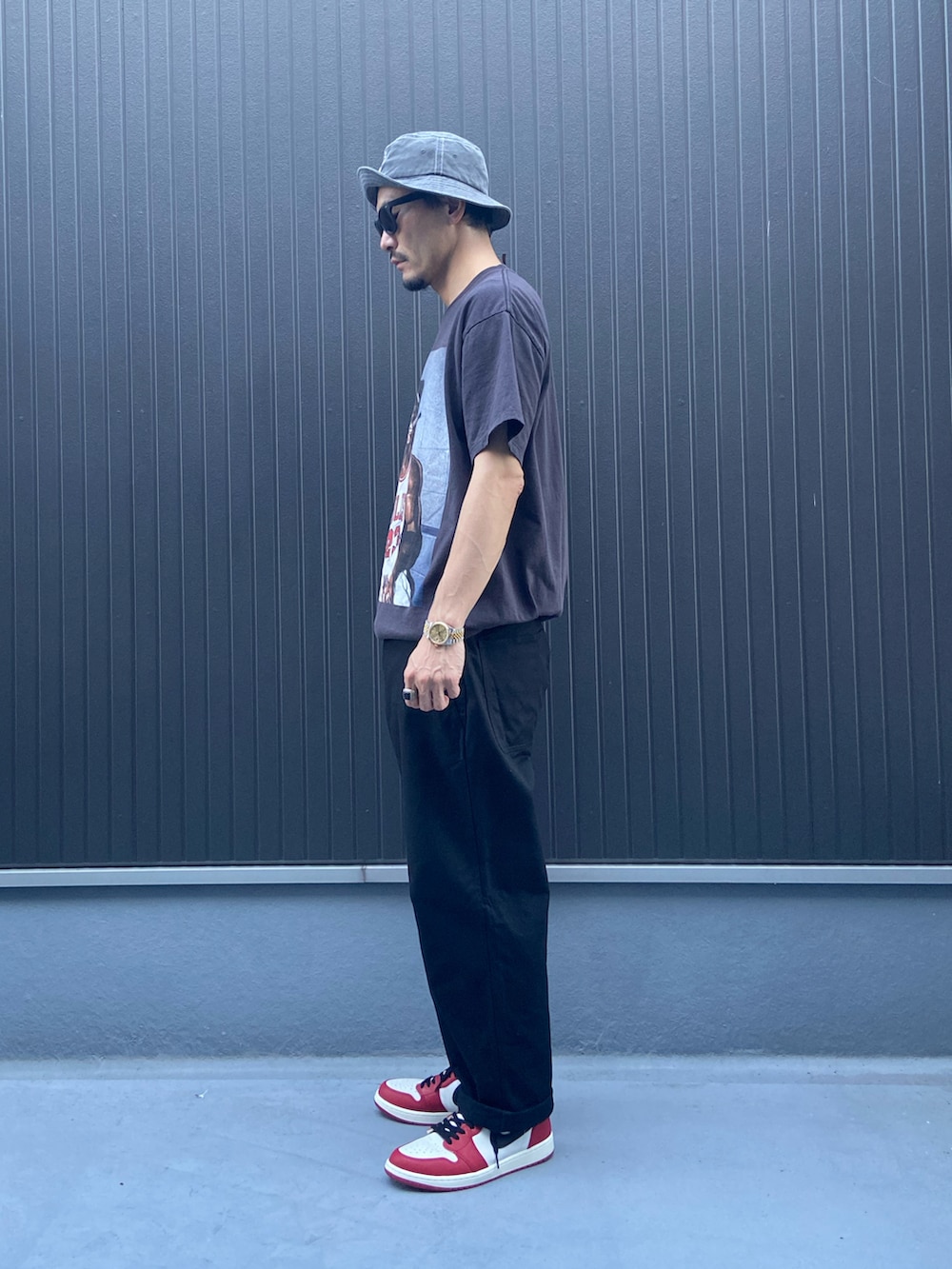 ブラック系のTシャツ/カットソー、ブラック系のパンツ、レッド系のスニーカーを着用したメンズの夏コーディネートの2枚目の写真