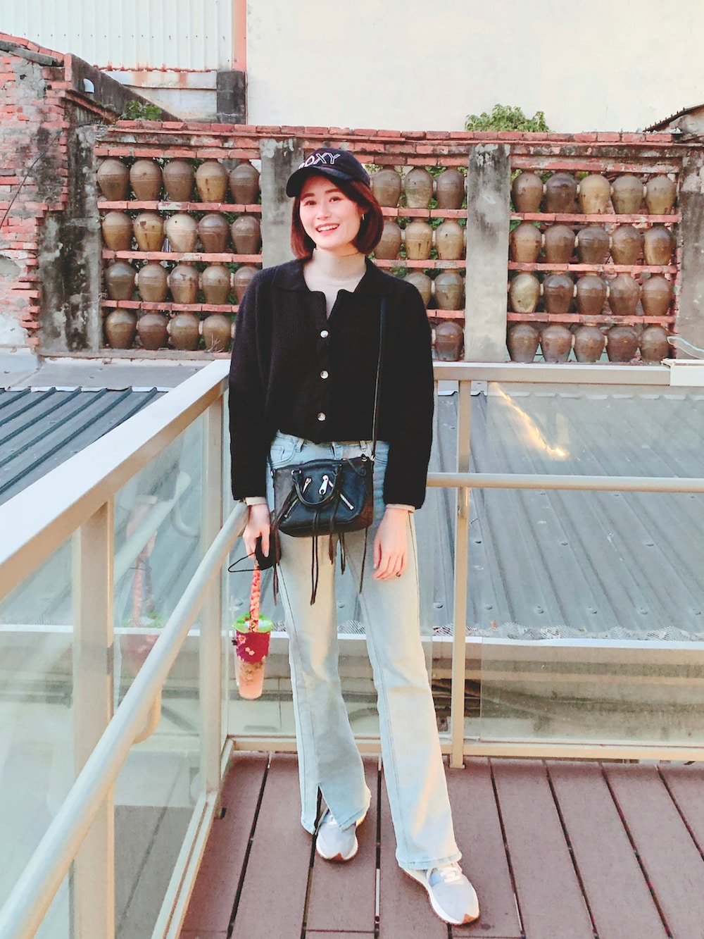 グレー系のスニーカー、ブルー系のデニムパンツ、ブラック系のキャップを着用したレディースの冬コーディネートの2枚目の写真