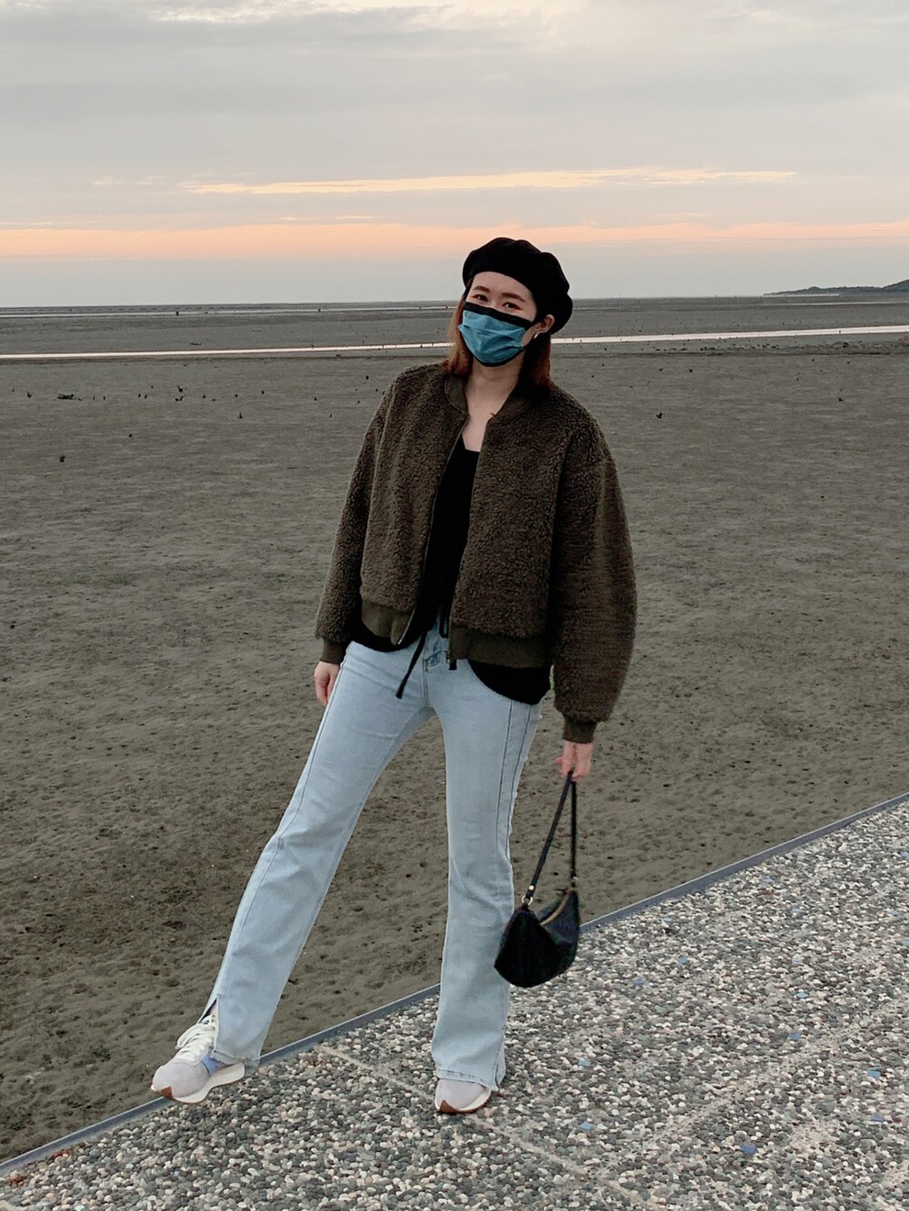 ブラック系のトートバッグ、グレー系のスニーカー、グリーン系のその他アウターを着用したレディースの冬コーディネートの2枚目の写真