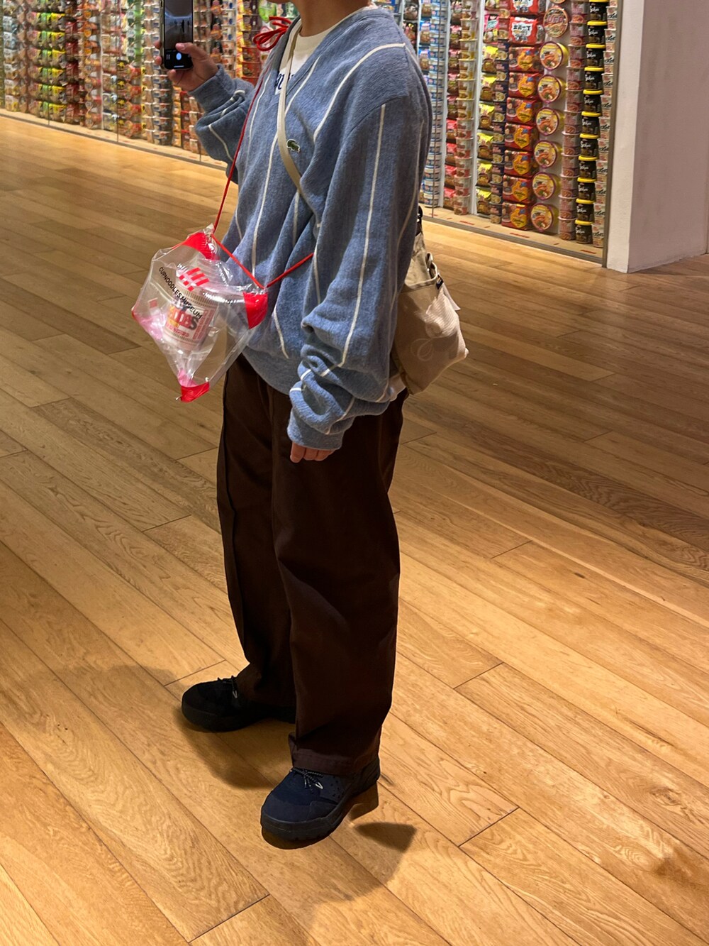 ブルー系のニット/セーター、ブラウン系のチノパンツ、ブルー系のスニーカーを着用したメンズの春コーディネートの2枚目の写真